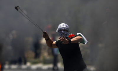 A Palestinian protester hurls a stone during clashes with Israeli forces