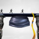 Photo of graduates crossing a gap filled by a graduation mortar cap