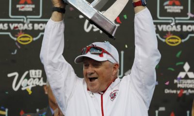 Photo of Fresno State football coach Jeff Tedford holding the trophy