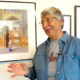 Photographer Helen Gigliotti stands next to a photo from her trip to Iran.