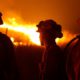 Photo of CDCR inmates standing guard as flames from the Butte fire approach a containment line