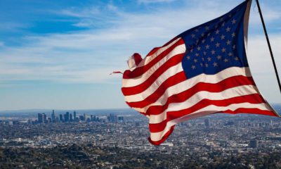 Photo of a flag waving with Los Angeles skyline in the background