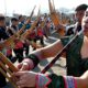 Photo of Phia Chia performing on a traditional Hmong instrument, the qeej