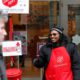 Photo of bell ringer Carolyn Harper encouraging people to donate