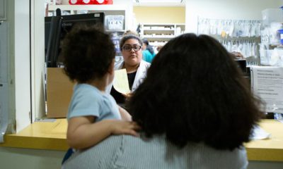 Photo of a family standing in line at a pharmacy