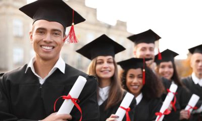 Photo of smiling college graduates holding their degrees