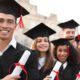 Photo of smiling college graduates holding their degrees