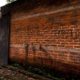 Photo of a police guard next to a graffiti wall in El Salvador