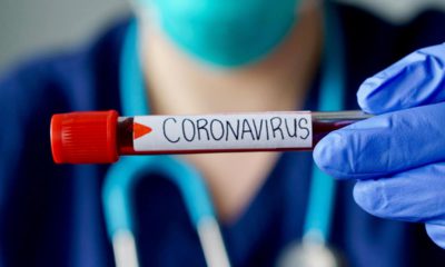 Photo of a physician holding a vial of blood marked coronavirus