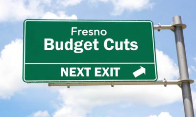 A freeway exit sign that says Fresno Budget Cuts