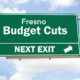 A freeway exit sign that says Fresno Budget Cuts