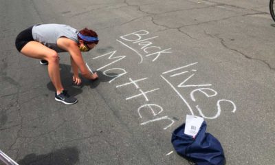 Photo of a protester writing "Black Lives Matter" in chalk on a downtown street in Fresno, California.