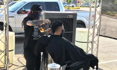 Picture of barber giving a haircut outdoors during California's ordered shutdown because of the coronavirus pandemic