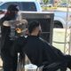 Picture of barber giving a haircut outdoors during California's ordered shutdown because of the coronavirus pandemic