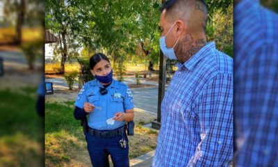 Image of a masked Fresno police officer talking to a masked resident