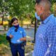 Image of a masked Fresno police officer talking to a masked resident