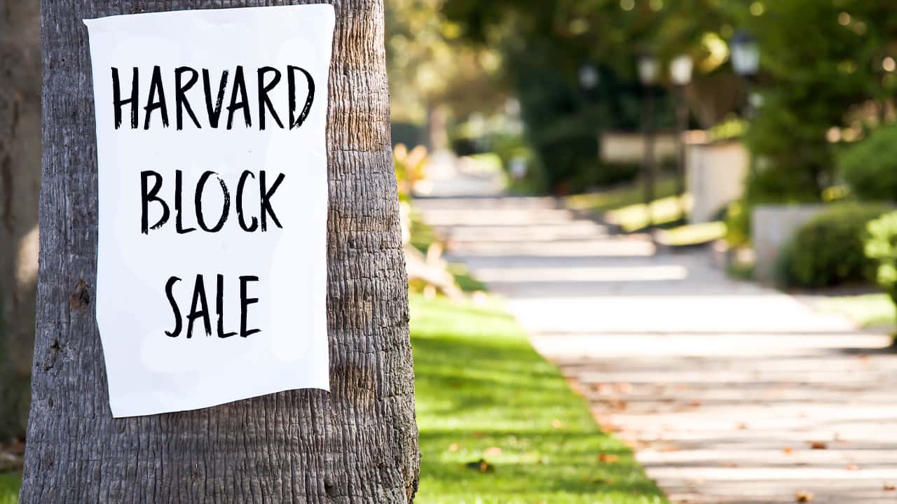 Photo of a Harvard Block Sale sign stuck to a tree in Fresno, California