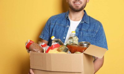 Picture of a young man carrying a box of donated groceries