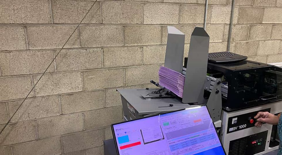 An ES & S machine scans ballot envelopes to match signatures to the registered voter on file (through a barcode). (GV Wire/David Taub)