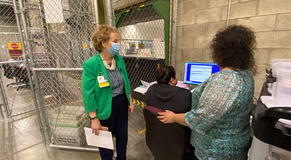 Fresno County Registrar of Voters Brandi Orth (left) and Nysen Armenta, program coordinator, oversee a manual verification of a signature. If the computer scan cannot determine a match, staff will make a visual check. (GV Wire/David Taub)